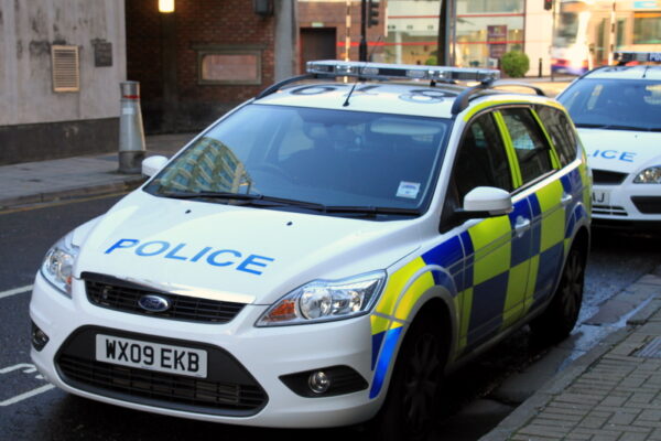 A car parked on a street saying "police" on it.