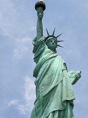 The Statue of Liberty pictured from below against a blue sky.