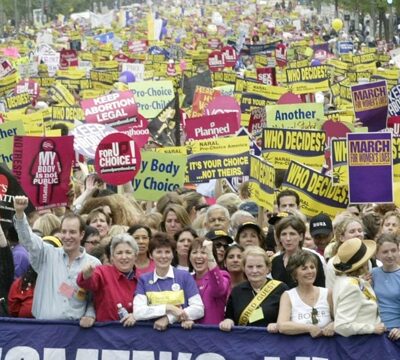 People hold up signs and slogans at a rally in support of reproductive rights.