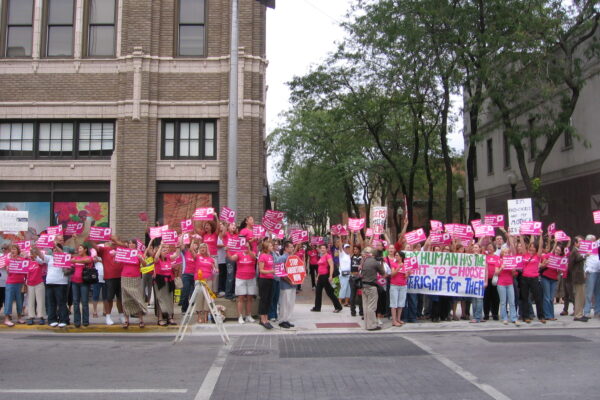 Women dressed in pink rally for reproductive rights.