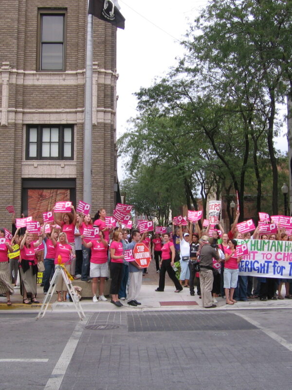Women dressed in pink rally for reproductive rights.