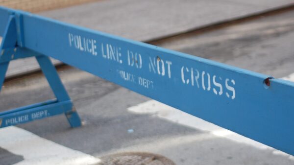 A blue barrier saying "Police Line Do Not Cross"
