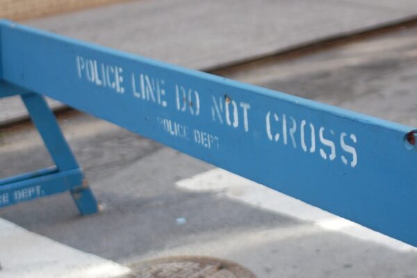 A blue barrier saying "Police Line Do Not Cross"