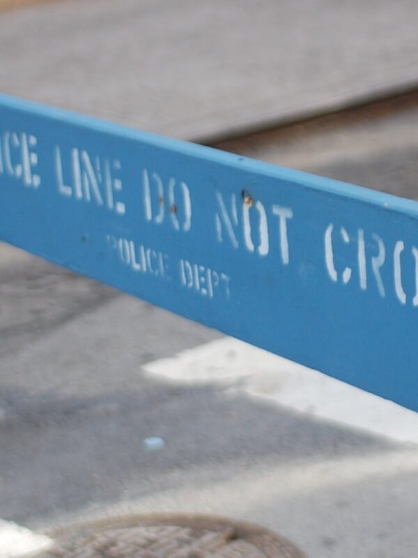 A blue barrier saying "Police Line Do Not Cross"