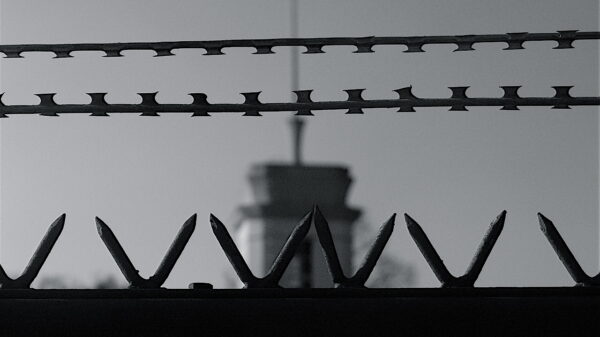A black and white image of a prison fence.