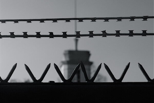 A black and white image of a prison fence.
