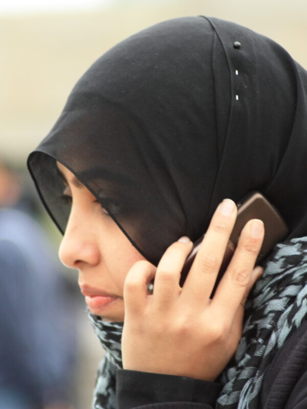 A woman in a black hijab used a smartphone