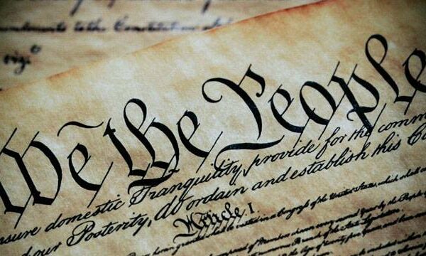 We the People in black ink on parchment paper.