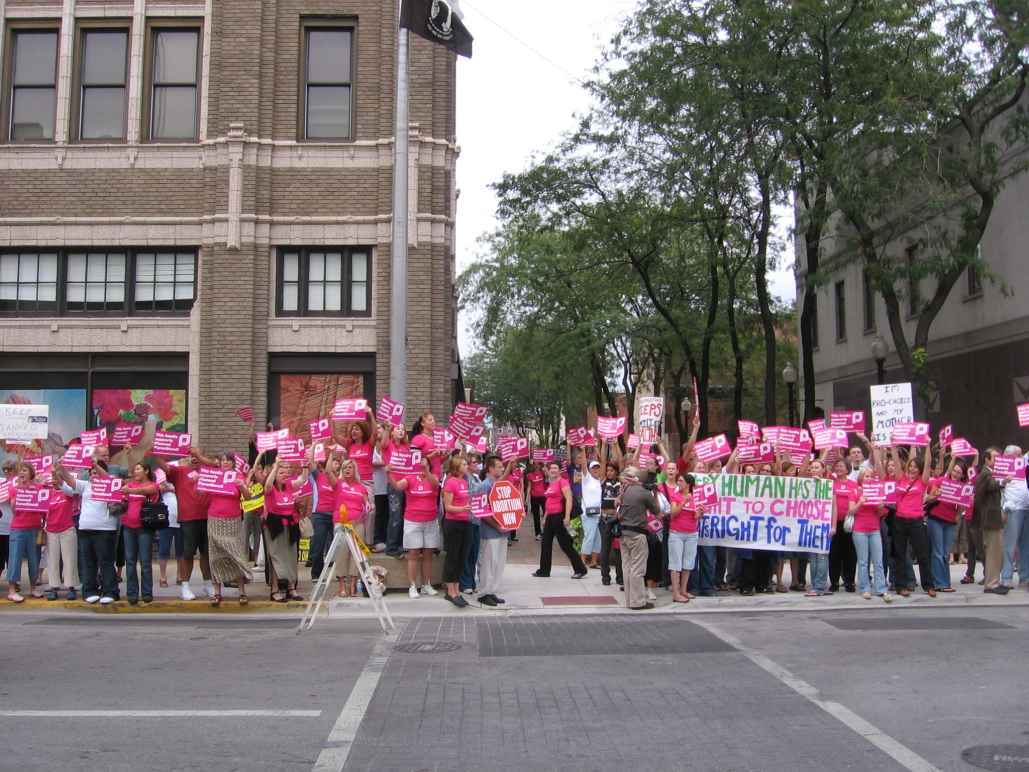 Women dressed in pink rally for reproductive rights.