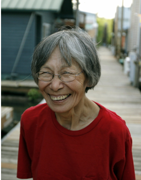 Joan Hamilton, an Alaska Native woman, stands on a deck.