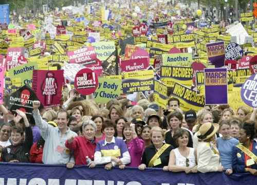 People hold up signs and slogans at a rally in support of reproductive rights.