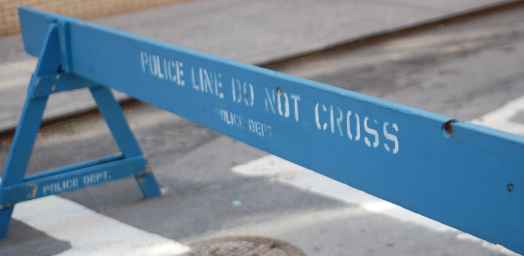 A blue barrier saying &quot;Police Line Do Not Cross&quot;