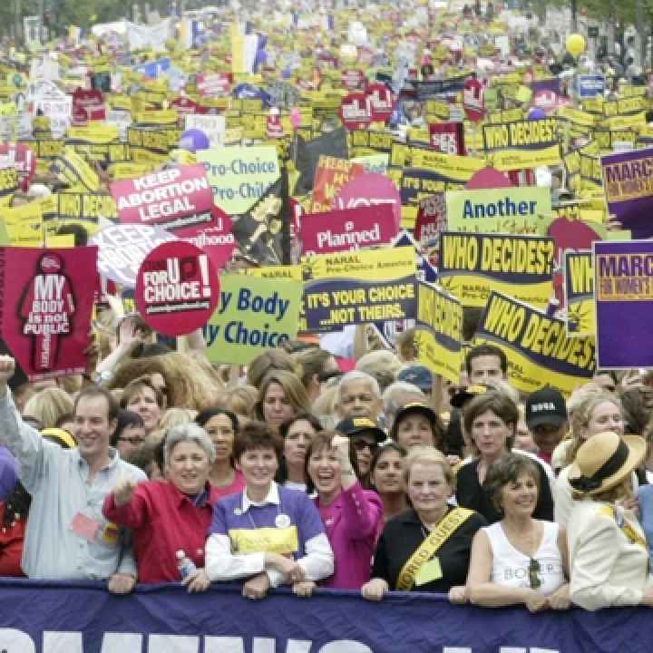 Women hold up signs and slogans at a rally in support of reproductive rights. People hold up signs and slogans at a rally in support of reproductive rights.